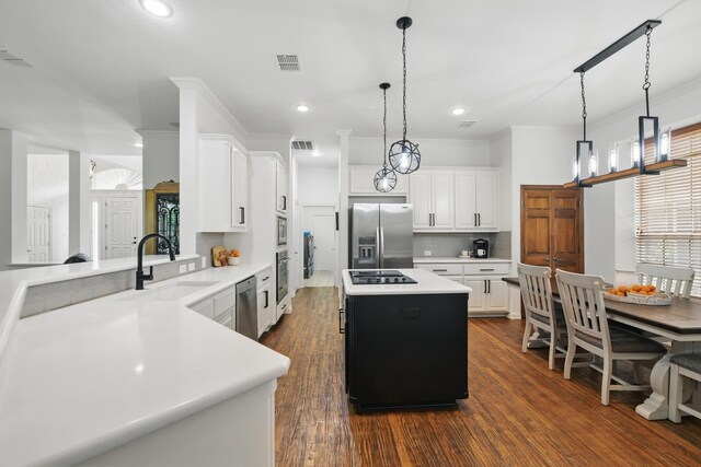 kitchen with dark wood-type flooring, a sink, appliances with stainless steel finishes, and light countertops