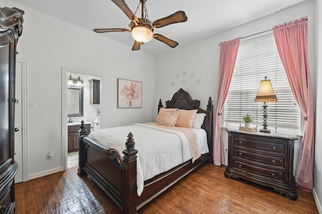 bedroom featuring connected bathroom, baseboards, dark wood-style floors, and ceiling fan