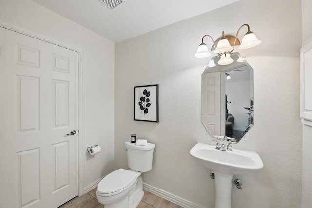 bathroom with toilet, tile patterned floors, visible vents, and baseboards