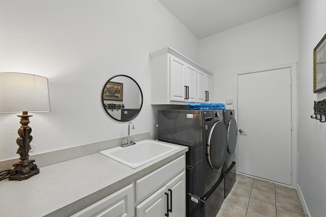 clothes washing area with washer and dryer, baseboards, a sink, cabinet space, and light tile patterned floors