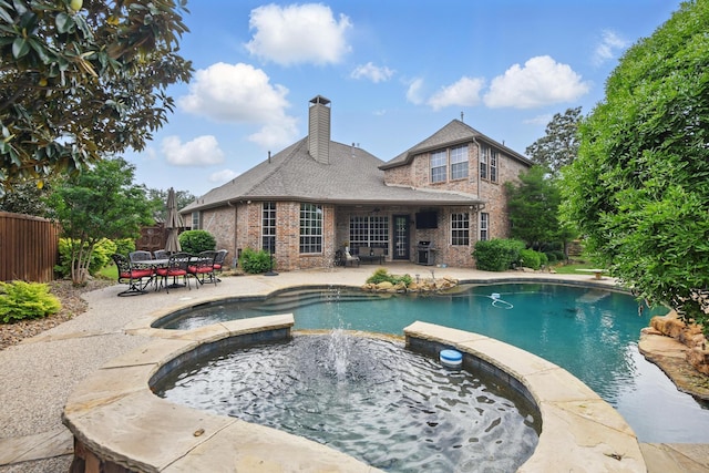pool featuring an in ground hot tub, a patio area, area for grilling, and fence