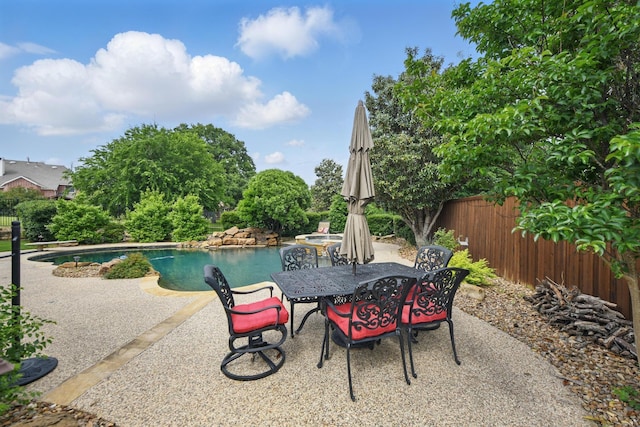 view of patio with a fenced in pool, outdoor dining area, and fence