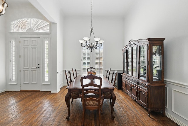 dining space featuring ornamental molding, dark wood-style floors, and a chandelier
