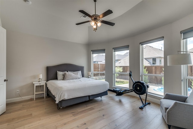 bedroom with baseboards, a ceiling fan, vaulted ceiling, and light wood finished floors