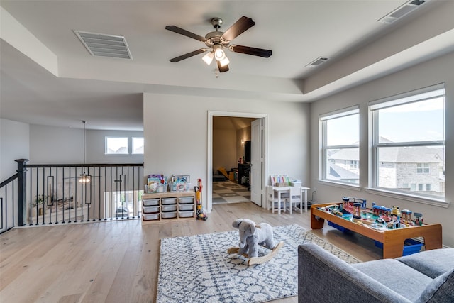 game room with a ceiling fan, visible vents, and light wood-style flooring