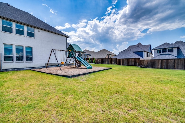 view of yard with fence, a playground, and a residential view