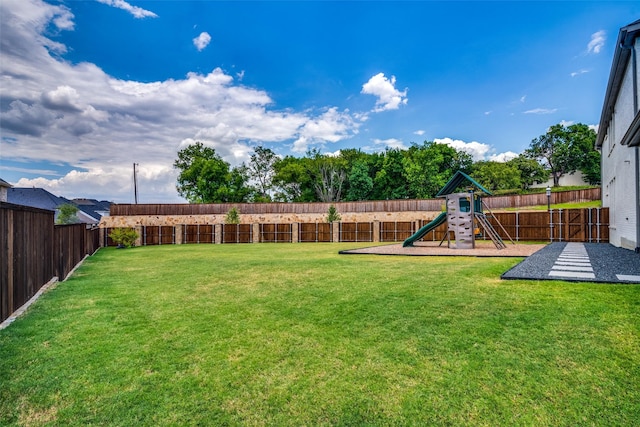 view of yard with a fenced backyard and a playground