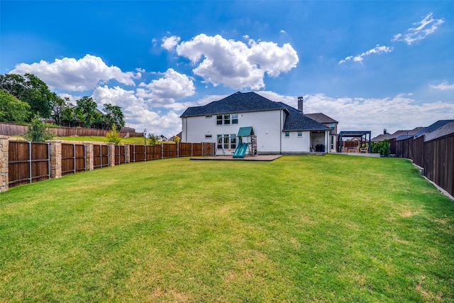 rear view of property with a lawn, a fenced backyard, and roof with shingles