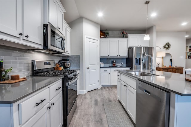 1349 Rolling Meadows Dr, Cedar Hill, TX 75104 - kitchen featuring a sink, tasteful backsplash, appliances with stainless steel finishes, recessed lighting, and light wood-style floors
