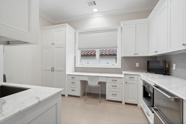 kitchen featuring built in desk, built in microwave, white cabinetry, visible vents, and ornamental molding
