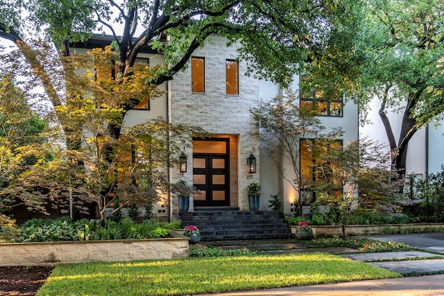 contemporary house featuring stone siding and stucco siding