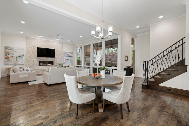 dining room with a fireplace, ceiling fan with notable chandelier, dark wood-style floors, and recessed lighting