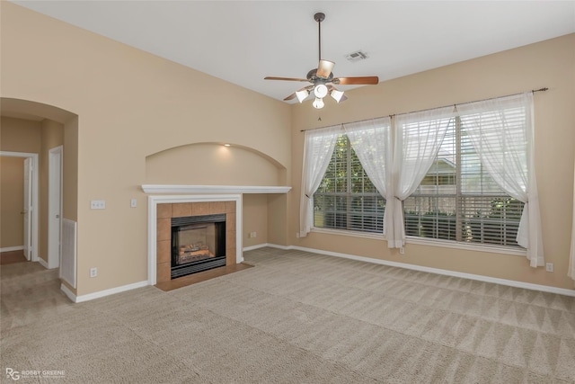 174 Hallette Dr, Shreveport, LA 71115 - unfurnished living room with carpet, ceiling fan, visible vents, arched walkways, and a tile fireplace