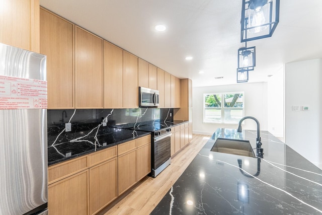 229 W Oaks Cir, Sulphur Springs, TX 75482 - kitchen featuring stainless steel appliances, a sink, light brown cabinetry, light wood-type flooring, and dark stone counters