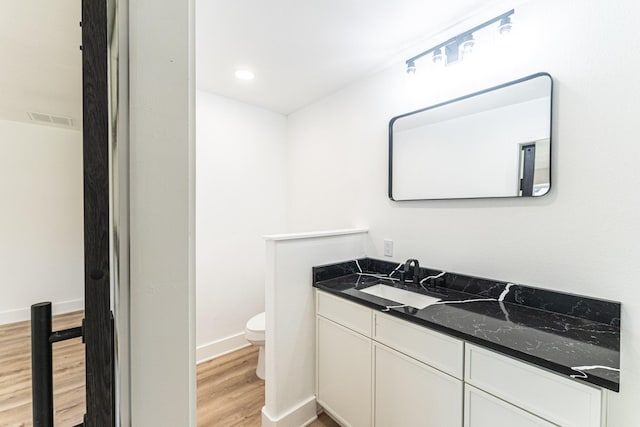 229 W Oaks Cir, Sulphur Springs, TX 75482 - bathroom featuring wood finished floors, toilet, vanity, and baseboards