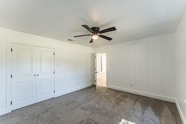 229 W Oaks Cir, Sulphur Springs, TX 75482 - unfurnished bedroom with dark colored carpet, baseboards, a closet, and ceiling fan