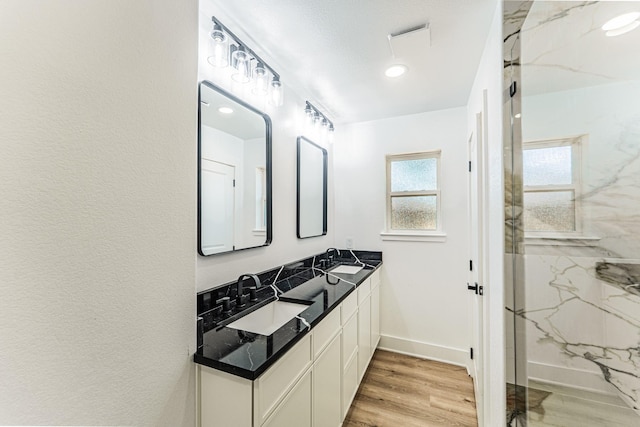 229 W Oaks Cir, Sulphur Springs, TX 75482 - bathroom featuring double vanity, a marble finish shower, wood finished floors, and baseboards