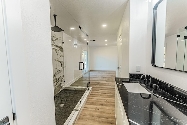229 W Oaks Cir, Sulphur Springs, TX 75482 - bathroom featuring a marble finish shower, wood finished floors, vanity, and recessed lighting