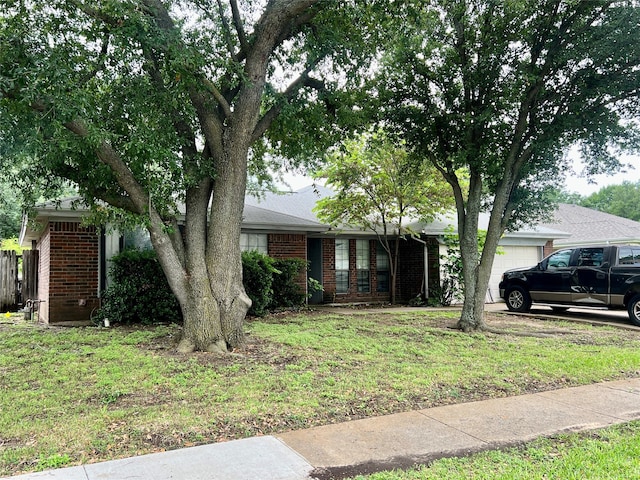 single story home featuring an attached garage, a front lawn, and brick siding