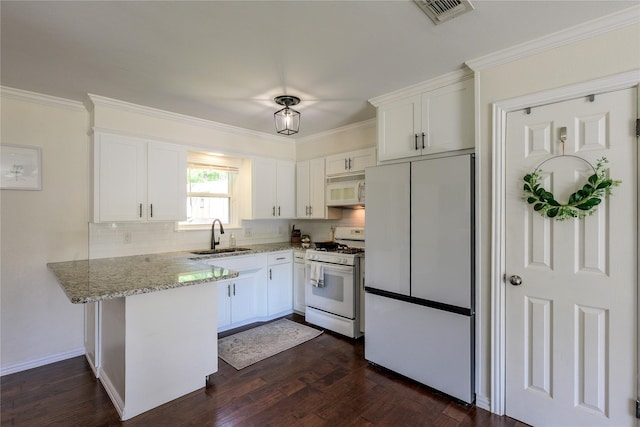 5921 Springbrook Dr, Tyler, TX 75707 - kitchen with white appliances, light stone counters, visible vents, a sink, and a peninsula