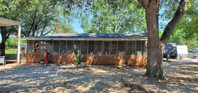 view of front of house with a sunroom and fence