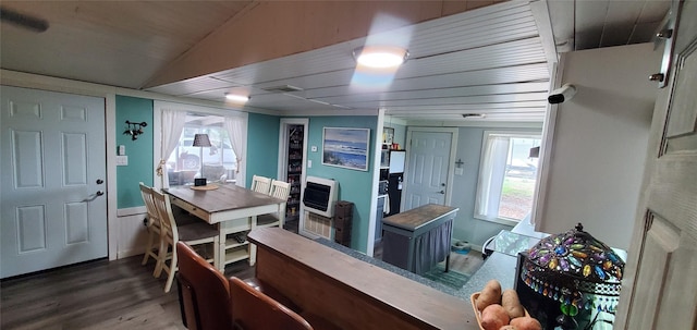 dining area featuring heating unit, a wealth of natural light, visible vents, and wood finished floors