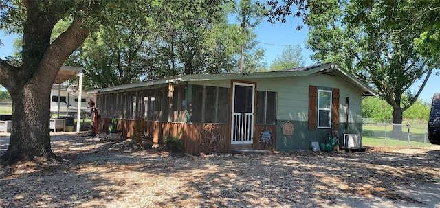 view of front of home featuring a sunroom and fence
