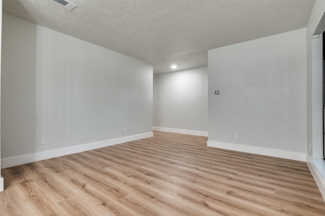 unfurnished room with light wood-style floors, visible vents, baseboards, and recessed lighting