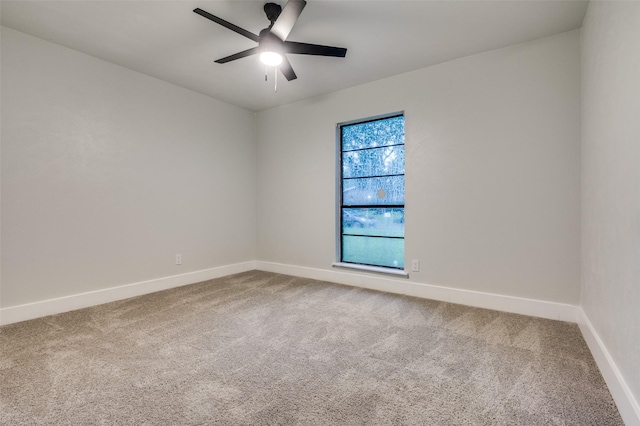spare room featuring baseboards, ceiling fan, and carpet