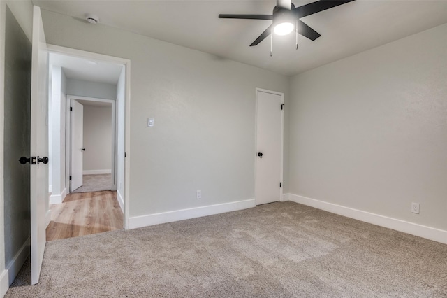 carpeted empty room featuring baseboards and a ceiling fan
