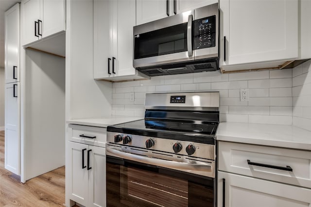 kitchen featuring light wood finished floors, light countertops, white cabinetry, and stainless steel appliances