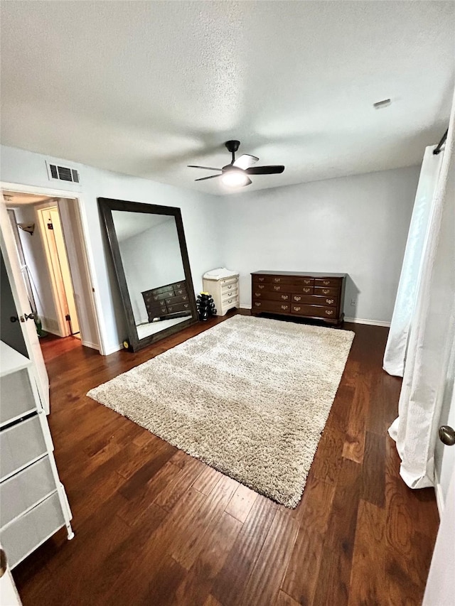 bedroom featuring a ceiling fan, visible vents, wood finished floors, and baseboards