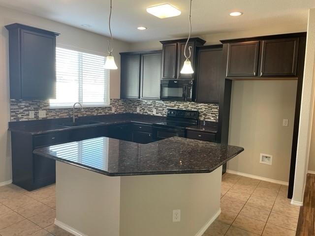 kitchen featuring a sink, tasteful backsplash, black appliances, and light tile patterned floors