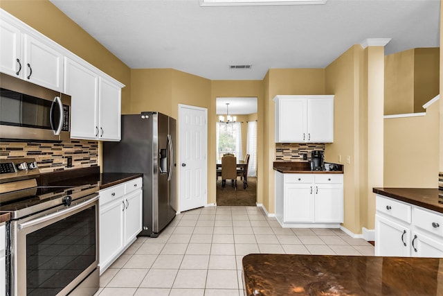 kitchen with a notable chandelier, visible vents, backsplash, dark countertops, and appliances with stainless steel finishes