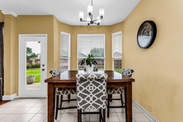 dining space featuring an inviting chandelier, light tile patterned floors, and baseboards