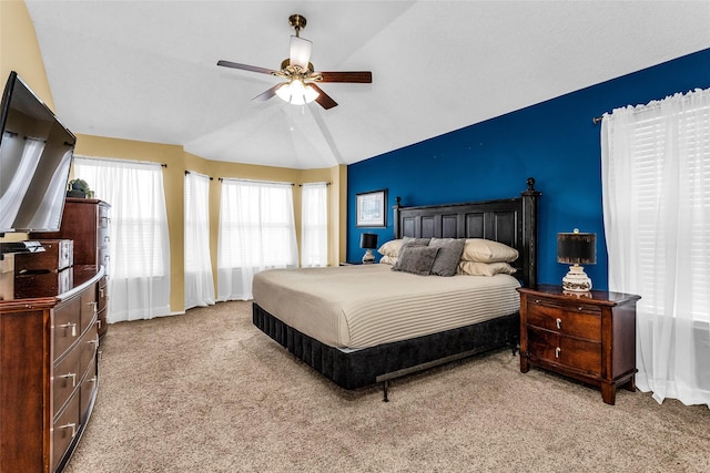bedroom with vaulted ceiling, light carpet, baseboards, and a ceiling fan