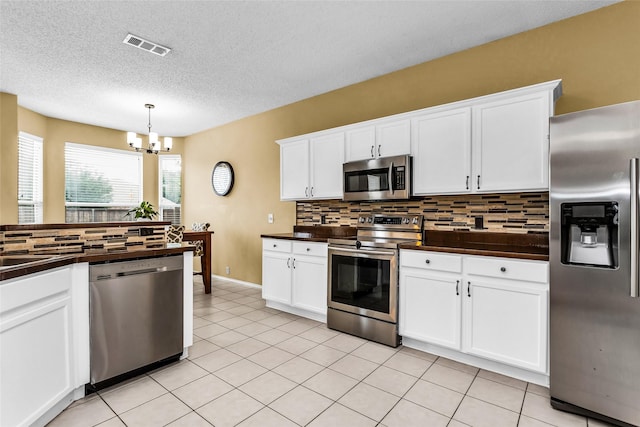 kitchen with backsplash, dark countertops, and appliances with stainless steel finishes