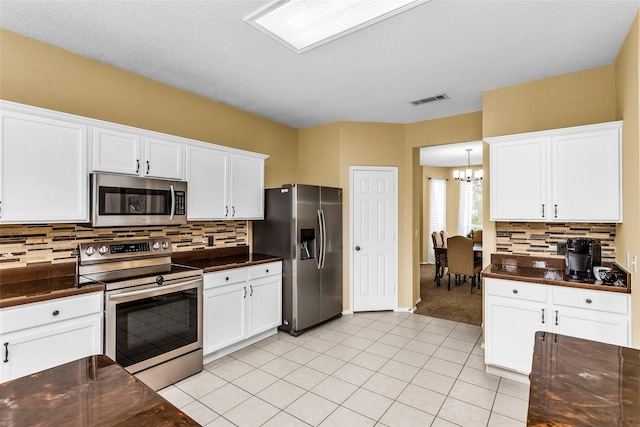 kitchen with dark countertops, visible vents, and appliances with stainless steel finishes
