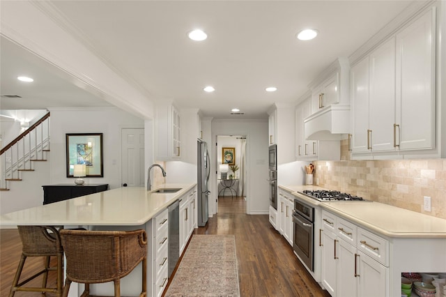 kitchen featuring a sink, backsplash, light countertops, white cabinets, and appliances with stainless steel finishes