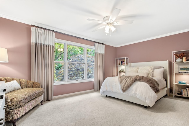 carpeted bedroom featuring baseboards, crown molding, and a ceiling fan