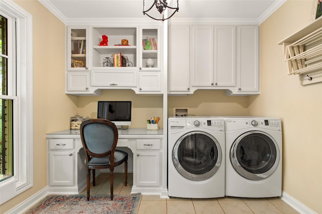 laundry room featuring washing machine and dryer, baseboards, light tile patterned floors, an inviting chandelier, and cabinet space