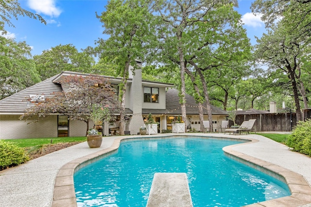 view of swimming pool with a patio area, fence, a diving board, and a fenced in pool