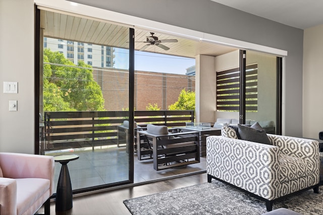 living area with wood finished floors and ceiling fan