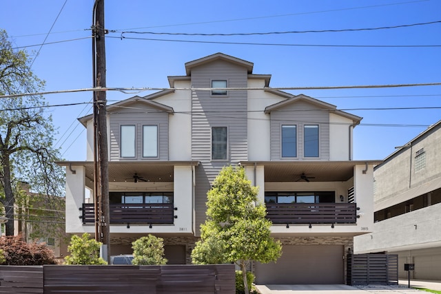 view of front facade featuring ceiling fan, a balcony, a garage, and concrete driveway