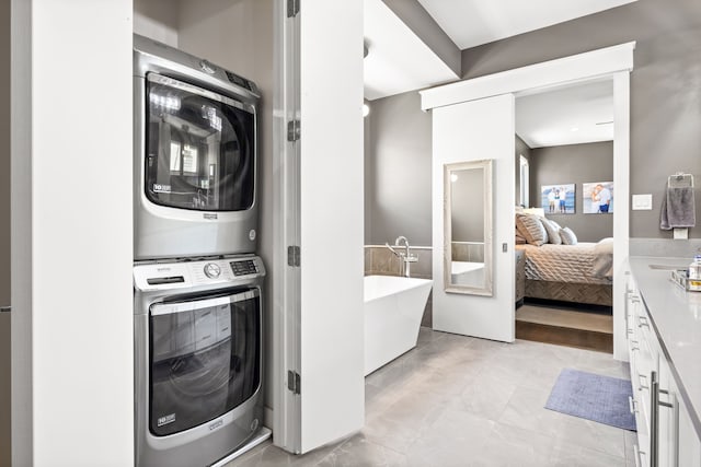 laundry area featuring stacked washer / drying machine