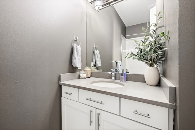 bathroom featuring vanity, a textured wall, and a shower with shower curtain