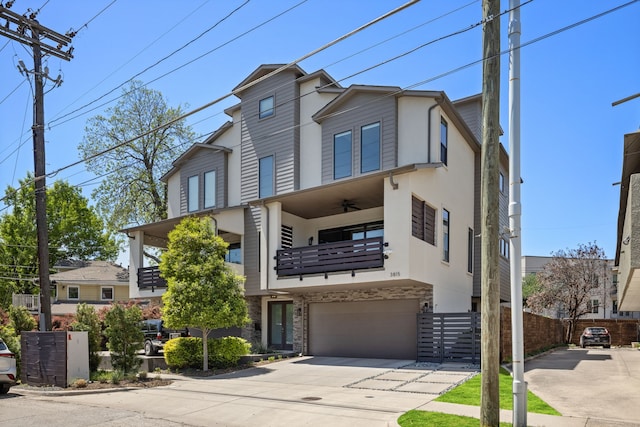 view of property featuring a balcony, an attached garage, stone siding, stucco siding, and concrete driveway