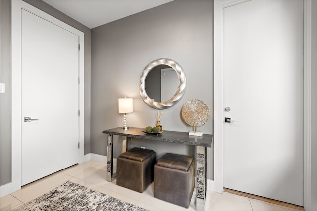 entryway with light tile patterned floors and baseboards