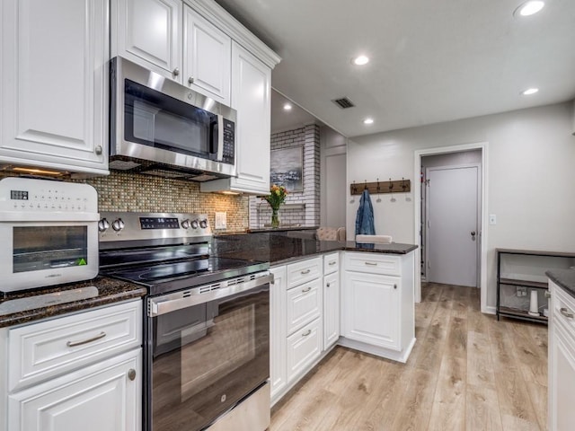 17607 Seedling Ct, Dallas, TX 75287 - kitchen featuring stainless steel appliances, a peninsula, white cabinetry, backsplash, and light wood finished floors