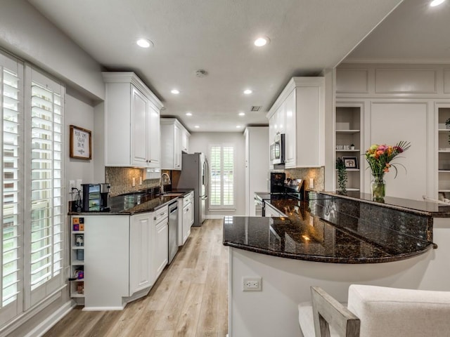 17607 Seedling Ct, Dallas, TX 75287 - kitchen with appliances with stainless steel finishes, recessed lighting, light wood-type flooring, white cabinets, and a sink